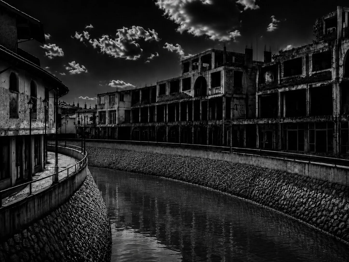 A gutted, roofless shell of a bazaar building beside the river, still standing in ruins.
